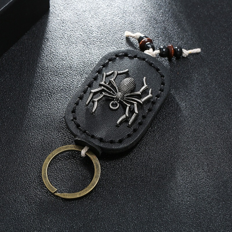 Vintage handmade leather keychain with a silver spider pendant and key ring, perfect for accessorizing bags.