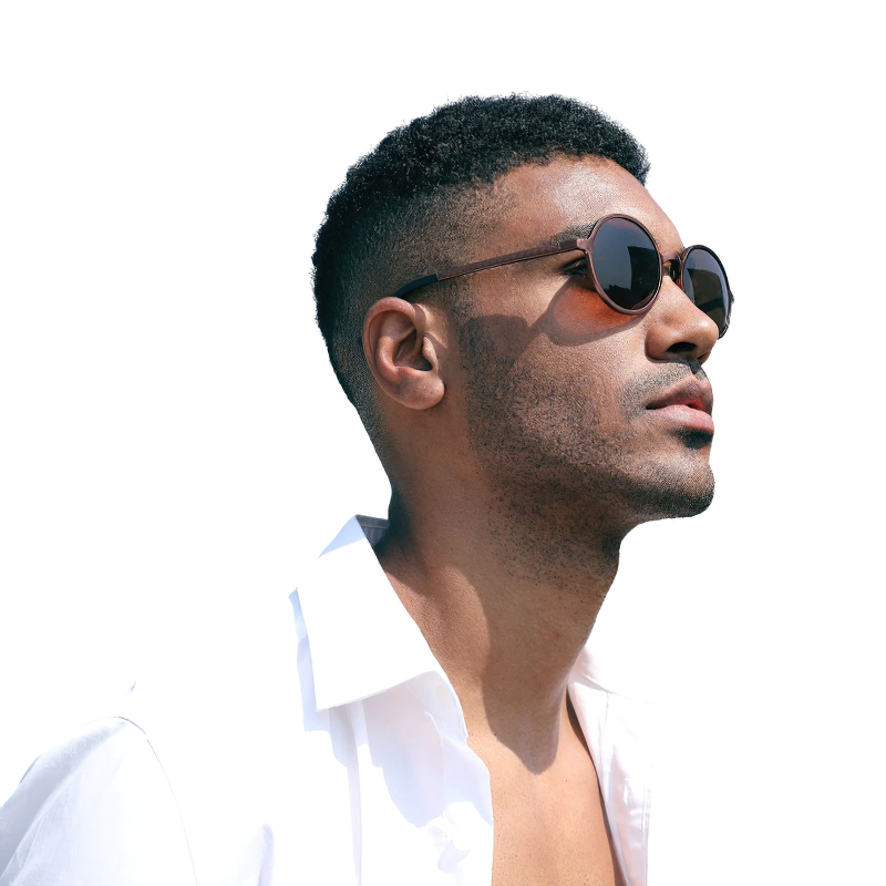 Stylish man wearing unisex luxury round sunglasses against a white background, showcasing vintage eyewear.