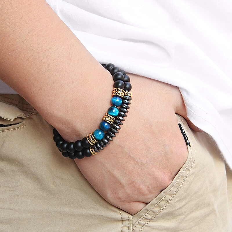 Unisex natural stone beaded bracelet on wrist, featuring blue and black beads, stylish vintage accessory for men and women.
