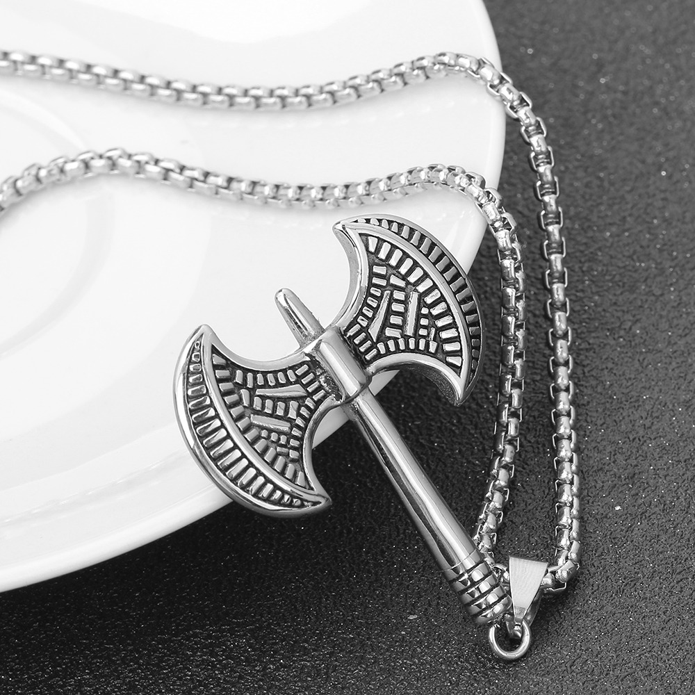 Handmade stainless steel Viking tomahawk pendant necklace on a plate, perfect for punk style outfits.