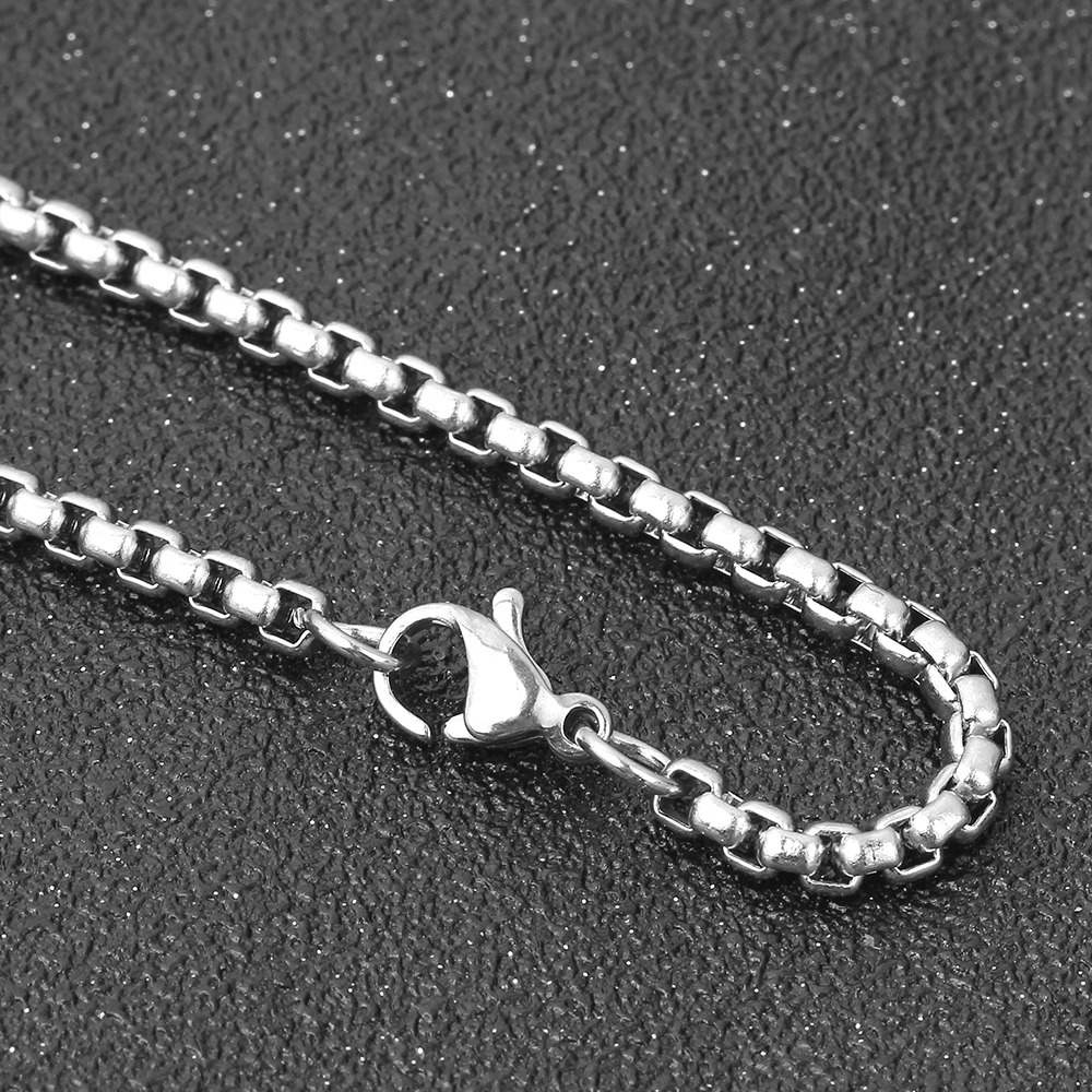 Close-up of a stainless steel chain necklace with a lobster clasp, perfect for punk-style accessories.