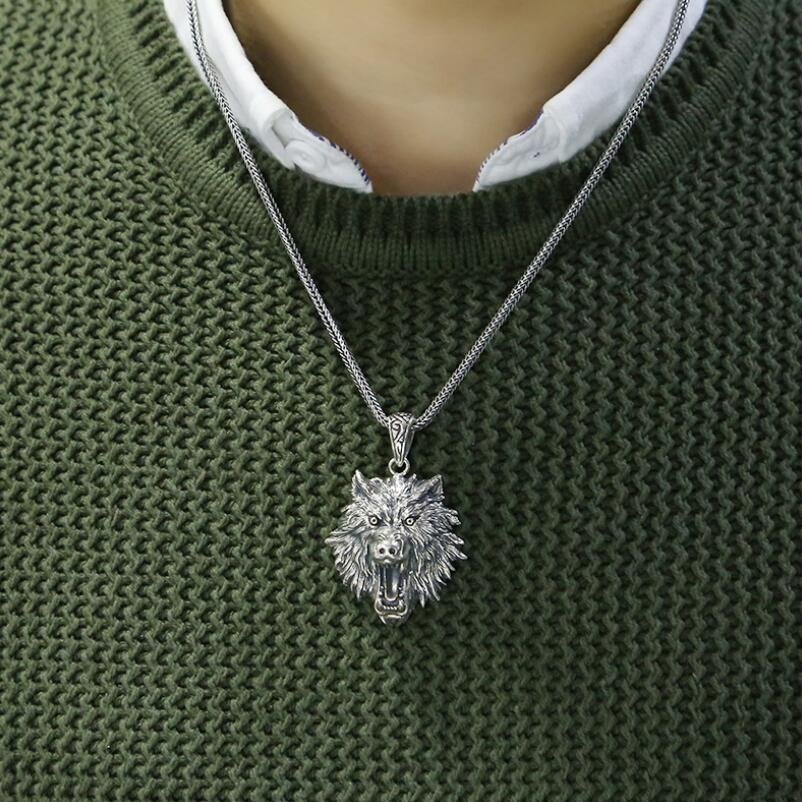 Unisex wolf head pendant in sterling silver worn on a green sweater, perfect for rock style outfits.