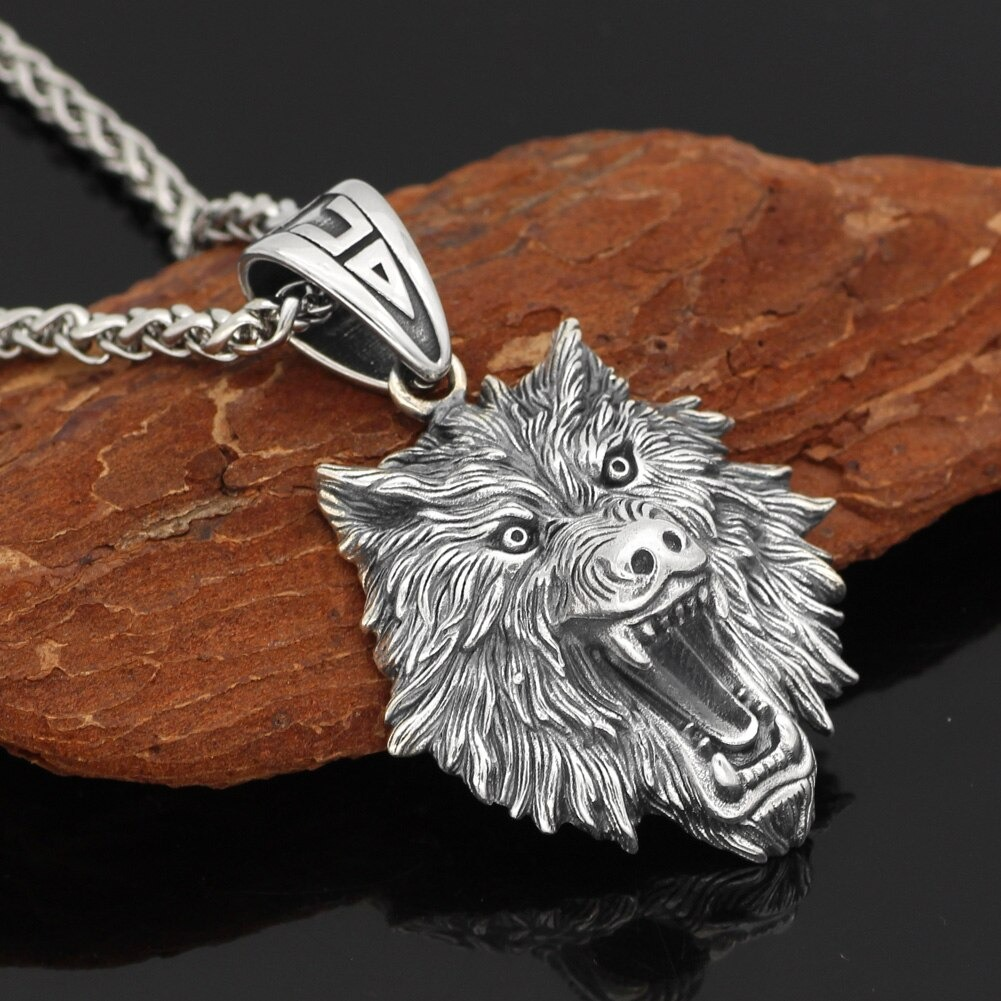 Sterling silver wolf head pendant on a wooden background, showcasing rock style vintage jewelry for unisex.