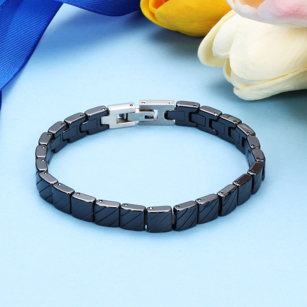 Unisex stainless steel bracelet in black color, featuring toggle clasp, trendy fashion jewelry on a pastel background.