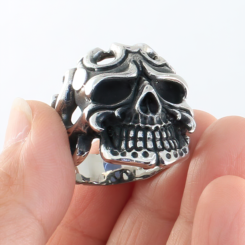 Close-up of a unisex stainless steel Gothic skull ring held in hand, perfect for rock or punk styles.