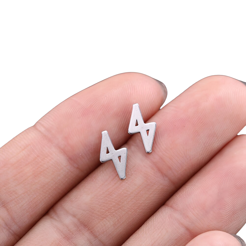 Unisex vintage silver gothic earrings in stainless steel design, stylishly held in hand.