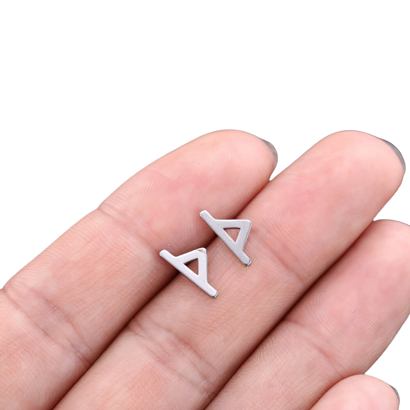 Unisex vintage silver earrings in a hand, showcasing trendy gothic style stainless steel design.