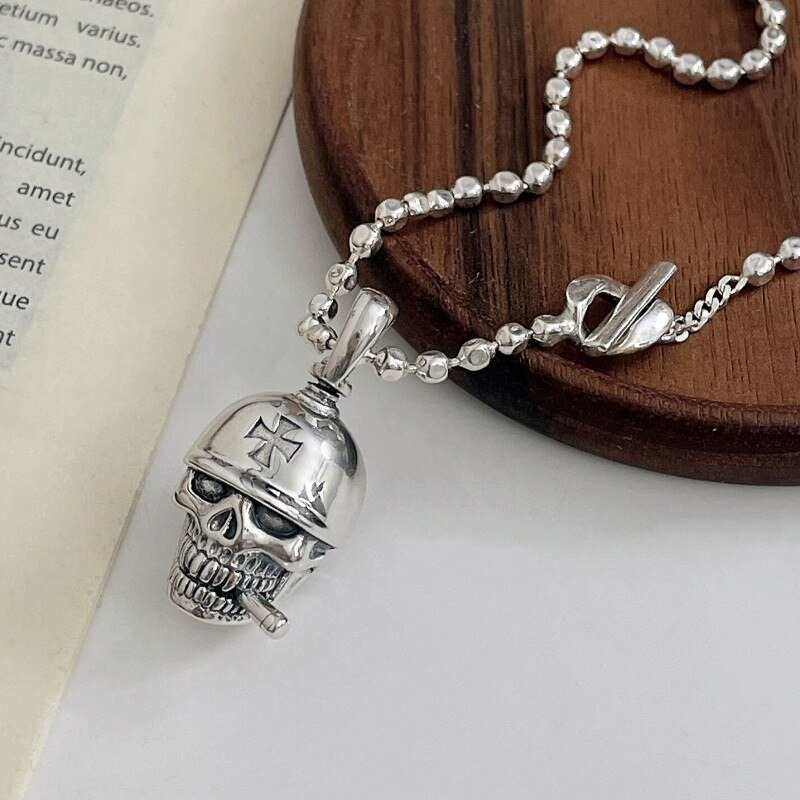 Unisex sterling silver skull pendant with helmet on a wooden surface, showcasing vintage punk style.