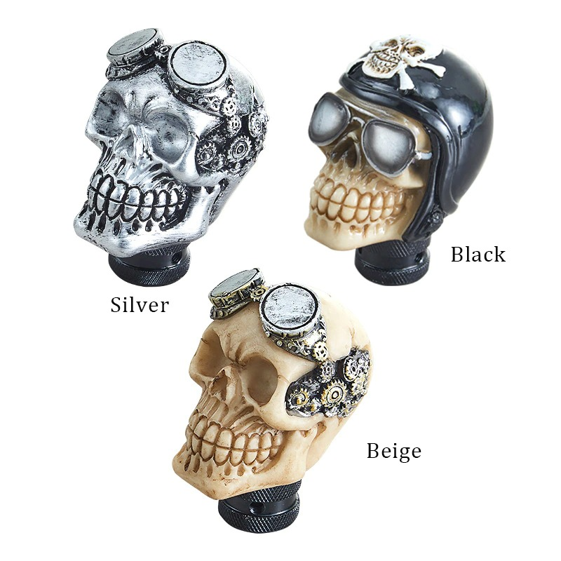 Three Gothic skull gearshift knobs in silver, black, and beige with cool accessories for cars.