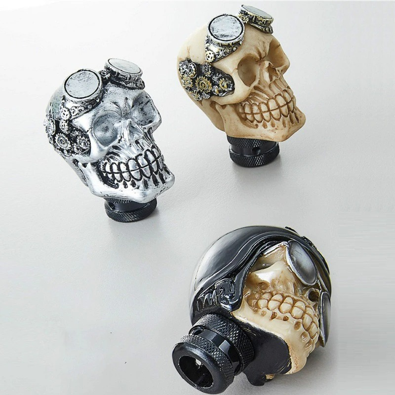 Three unique skull gearshift knobs in silver, cream, and black styles, perfect for adding a gothic touch to your car.