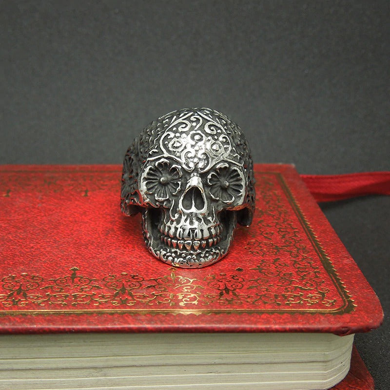 Vintage silver sugar skull ring on a red book, perfect for rock punk alternative fashion.