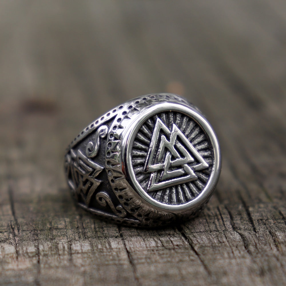 Viking stainless steel ring featuring Valknut Norse style runes on a wooden surface.