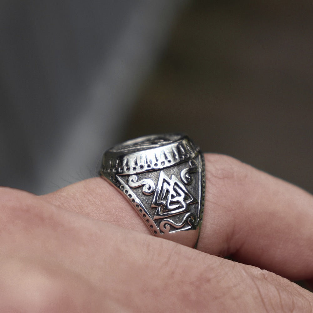 Close-up of Viking stainless steel ring featuring intricate Valknut Norse runes on a hand.
