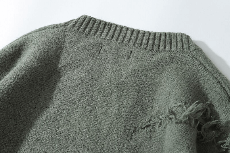 Close-up of the ribbed neckline and textured fabric of a vintage oversized knitted men's sweater.