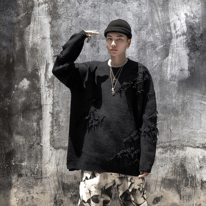 Men's vintage oversized knitted sweater with ripped design, styled with accessories and modern streetwear fashion.