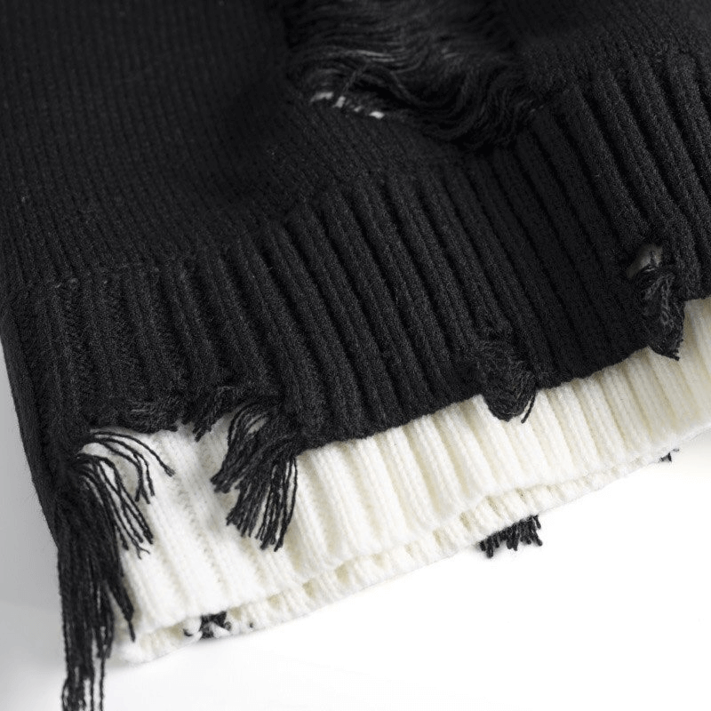 Close-up of the ripped design on a black and white knitted oversized sweater, showcasing vintage casual style.