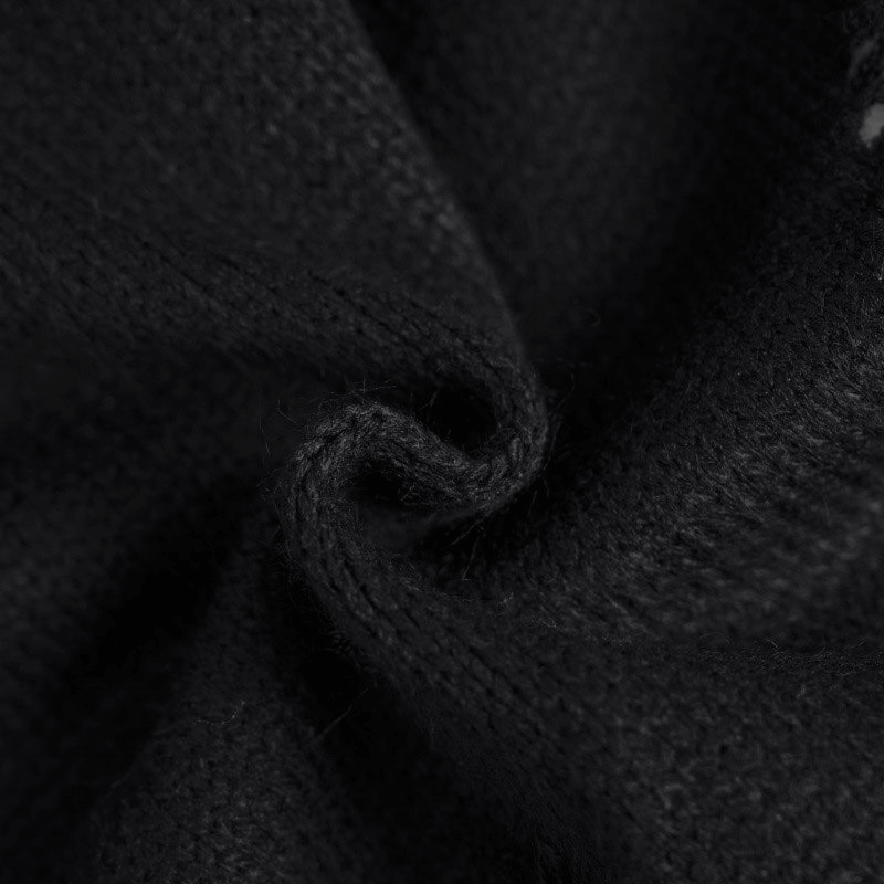 Close-up of soft black knitted fabric showcasing the texture of a vintage oversized sweater.