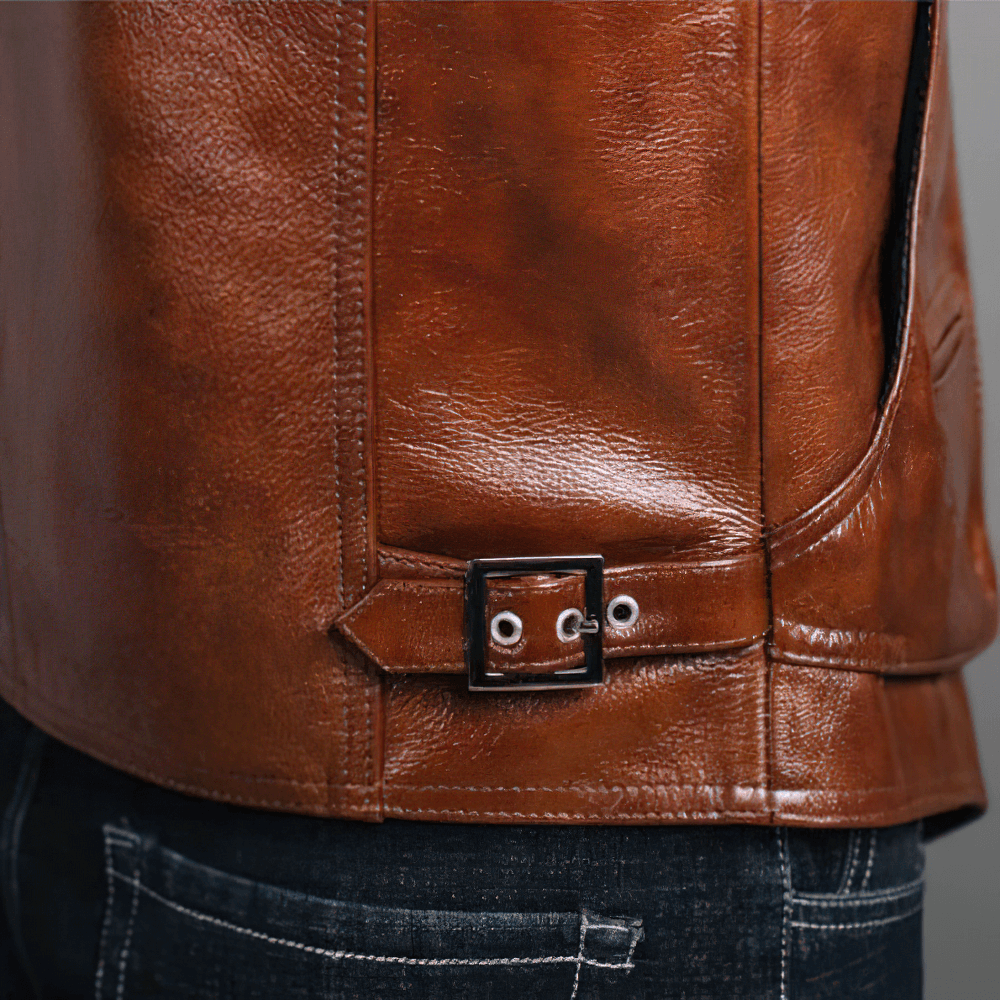 Close-up of a vintage brown leather vest featuring detailed stitching and a stylish buckle design.