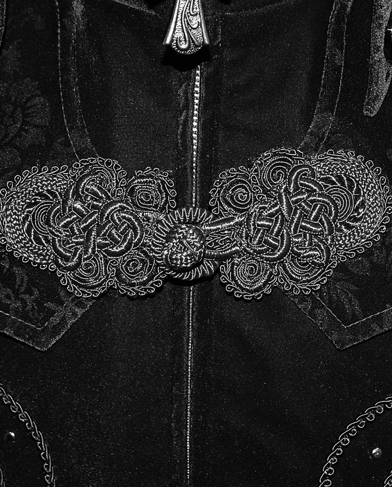 Close-up of ornate silver embroidery on a vintage black velvet coat in gothic style.