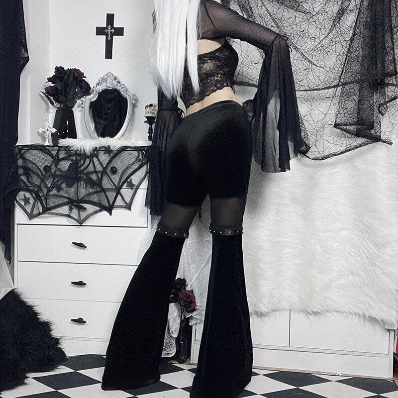 Model wearing vintage black velvet flare pants with mesh inserts, showcasing gothic style and unique vintage flair.