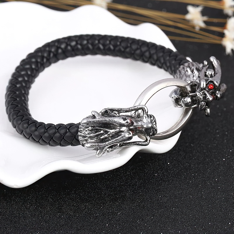 Vintage unisex bracelet featuring a metal skull and dragon head on braided leather, gothic style jewelry for men and women.