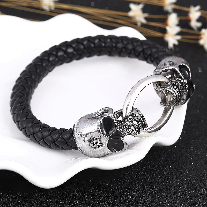 Vintage unisex gothic bracelet with metal skulls and braided leather, a unique handmade jewelry piece for men and women.