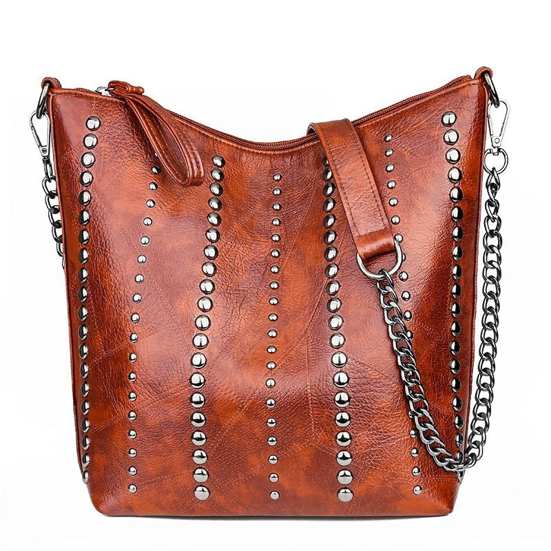 Vintage bucket shape handbag for women with rivets and chain strap, perfect for grunge outfits.