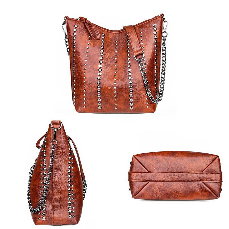 Vintage bucket shape bag for women in brown PU leather with rivets and chain strap, perfect for grunge outfits.