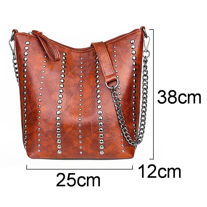 Vintage bucket shape handbag for women in brown PU leather with rivets and chain strap, dimensions 25x12x38 cm.