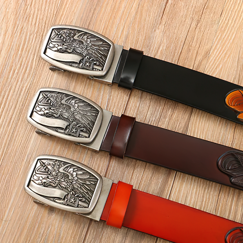 Vintage genuine leather cowboy belts with eagle buckles in three stylish colors on a wooden background.