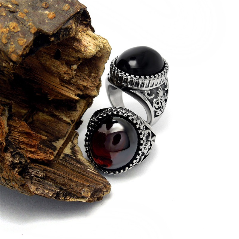 Vintage unisex stainless steel rings with big black and red stones displayed on wood. Perfect for alternative fashion and gifting.