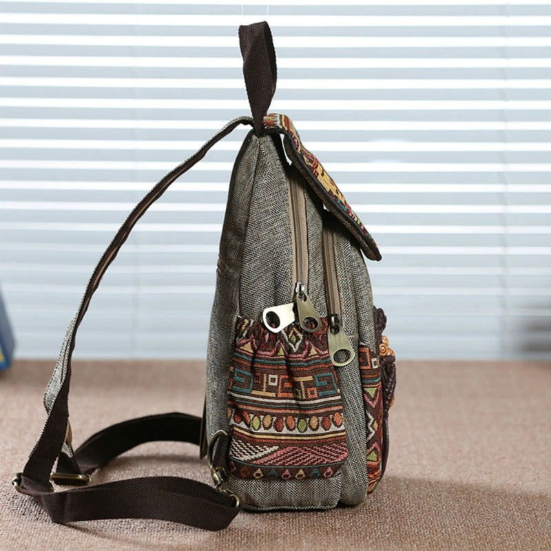 Side view of a vintage ethnic canvas backpack with colorful embroidery, perfect for travel and daily use.