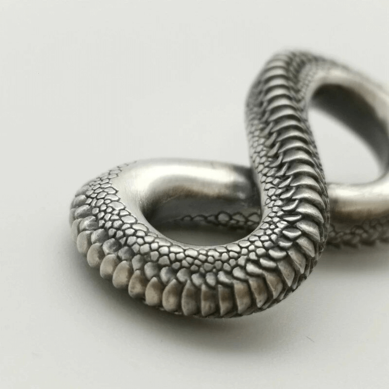 Close-up of vintage carving snake pendant, showcasing intricate details and punk style for unisex jewelry.
