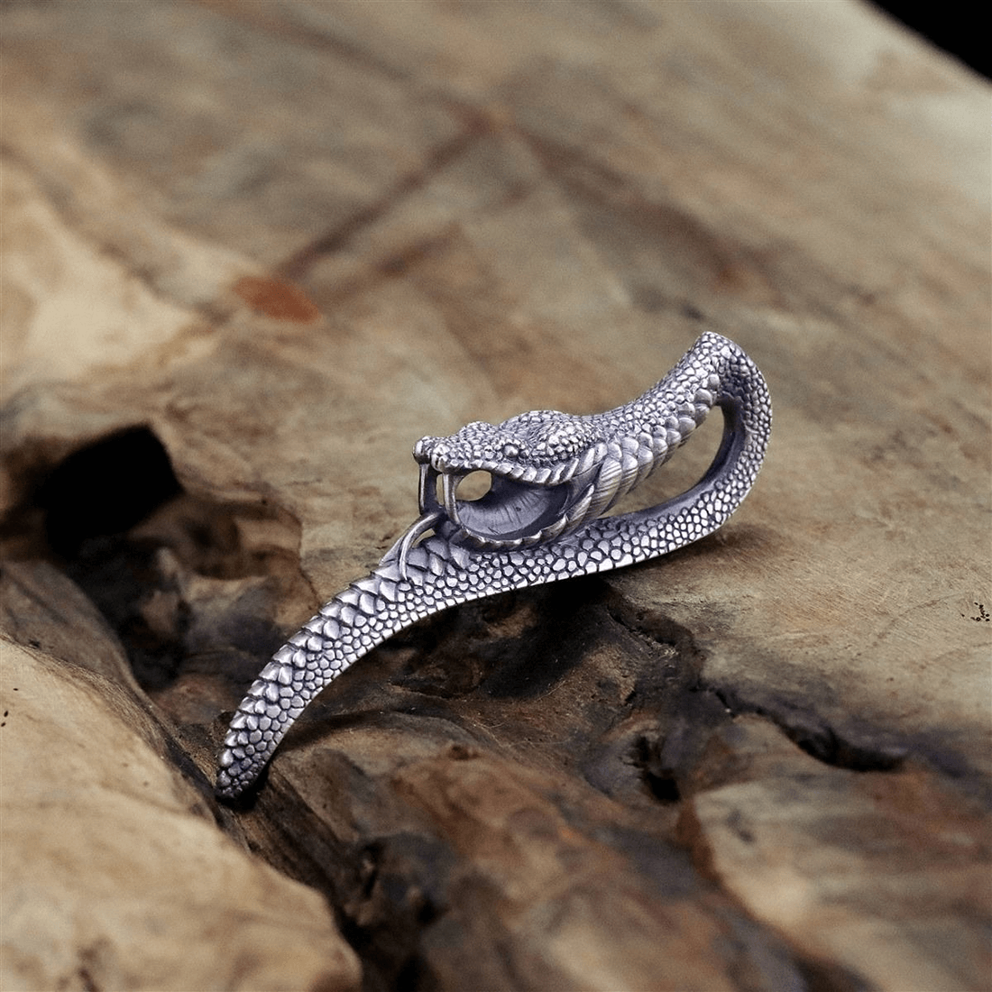 Vintage punk snake pendant on wooden surface, unisex design, stylish accessory for men and women.