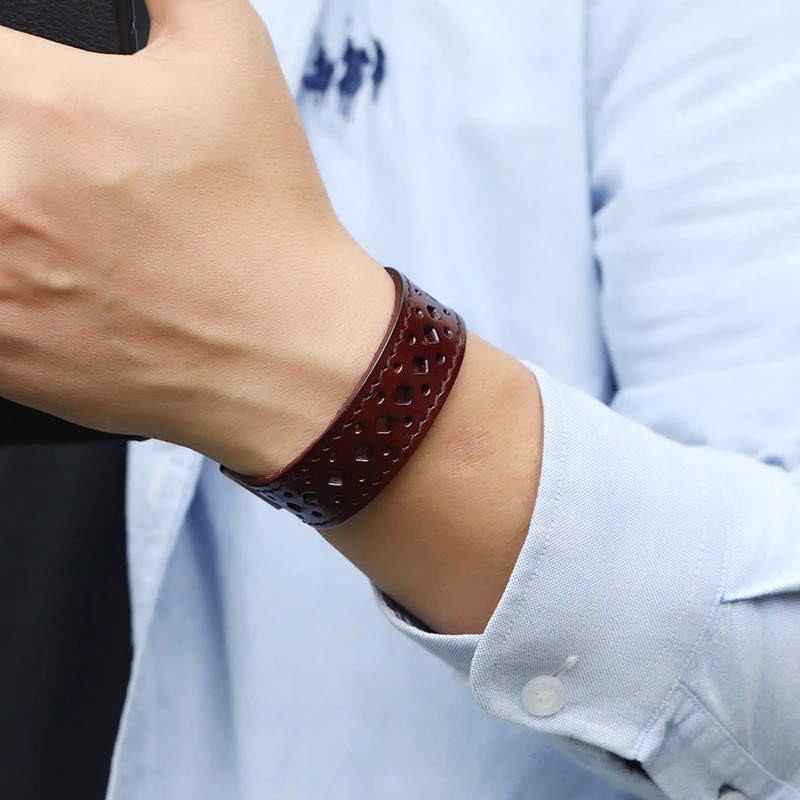 Close-up of a man wearing a vintage geometric pattern leather bracelet in brown on his wrist, showcasing its stylish design.