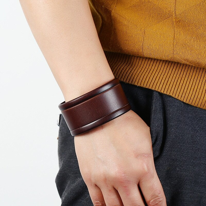 Vintage genuine leather wide bracelet on a wrist, showcasing a punk-rock style suitable for both men and women.