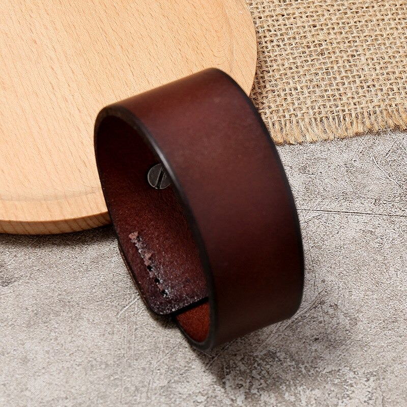 Vintage genuine leather wide cuff bracelet on a textured surface, perfect for unisex punk style.