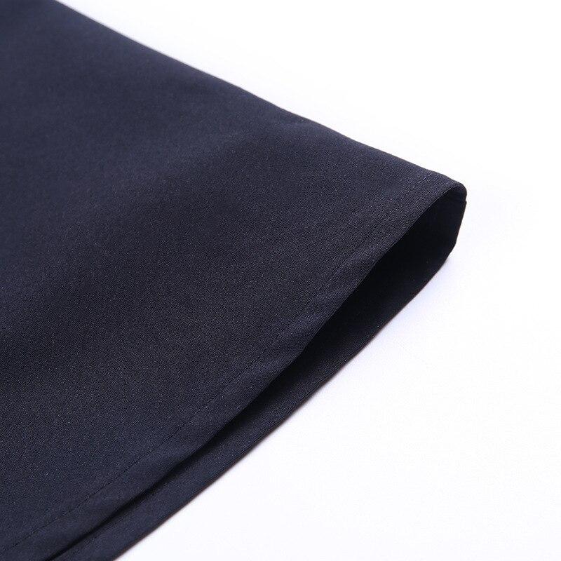 Close-up view of the hem of a black pleated gothic skirt, showcasing its sleek fabric and design details.