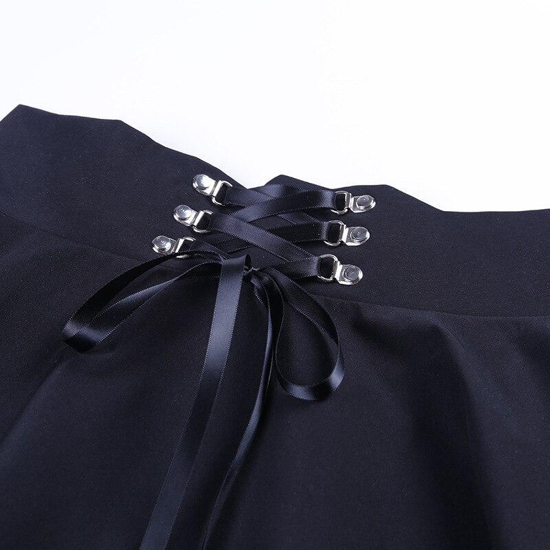 Close-up of the lace-up and rivet details on a black vintage gothic pleated skirt.