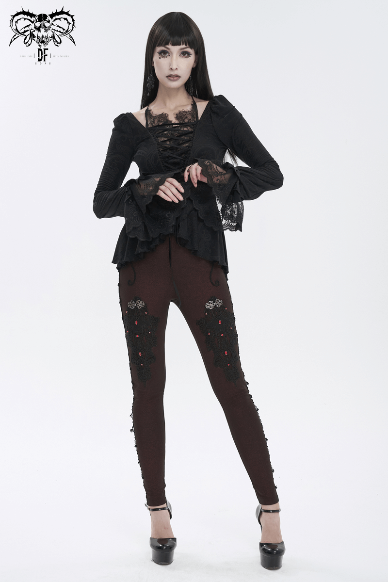 Vintage black top with flared lace sleeves and lace-up front, paired with stylish embroidered leggings.