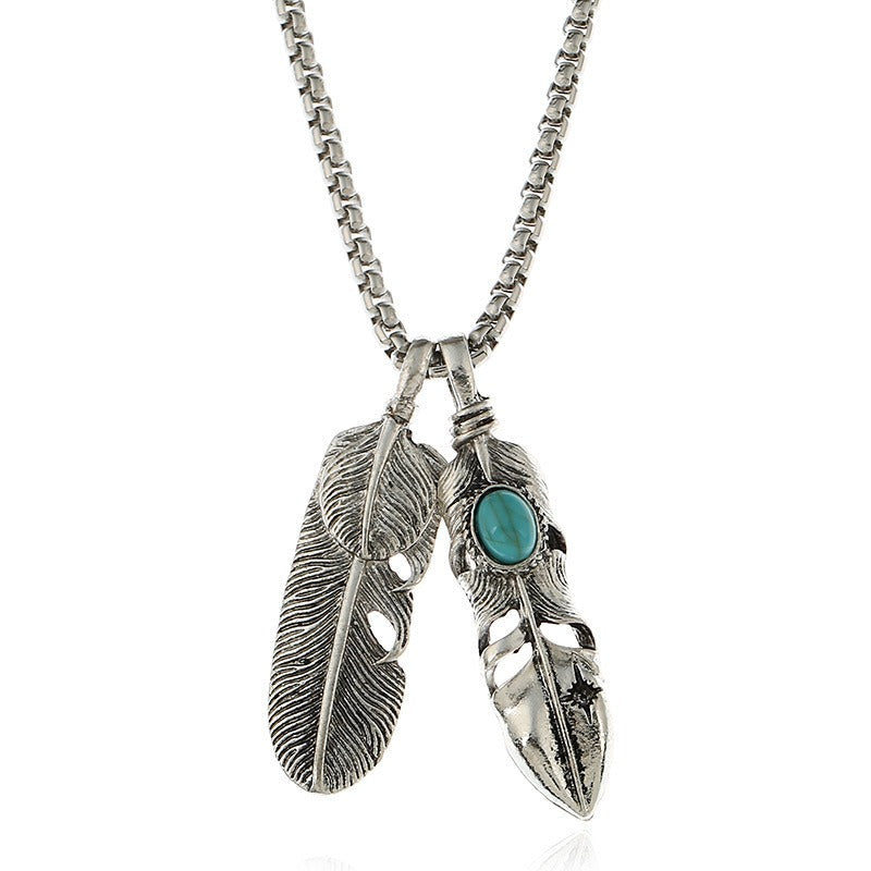 Vintage leaf pendant necklace with silver chains and turquoise feather detail, perfect for boho fashion lovers.