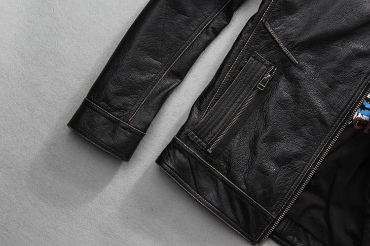 Close-up of a vintage black leather biker jacket showcasing zippers and textured fabric details.