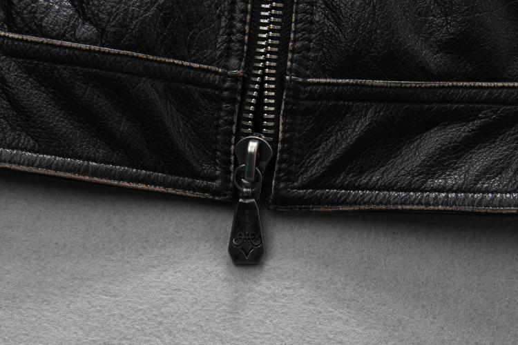 Close-up of a sleek black zipper on a vintage leather biker jacket, showcasing its quality and detail.