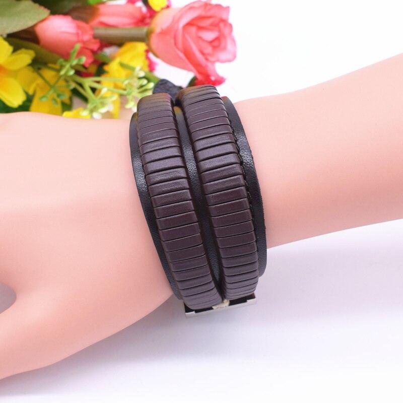 Vintage black leather cuff bracelet on wrist, featuring double wide design with zinc alloy details, perfect for men.