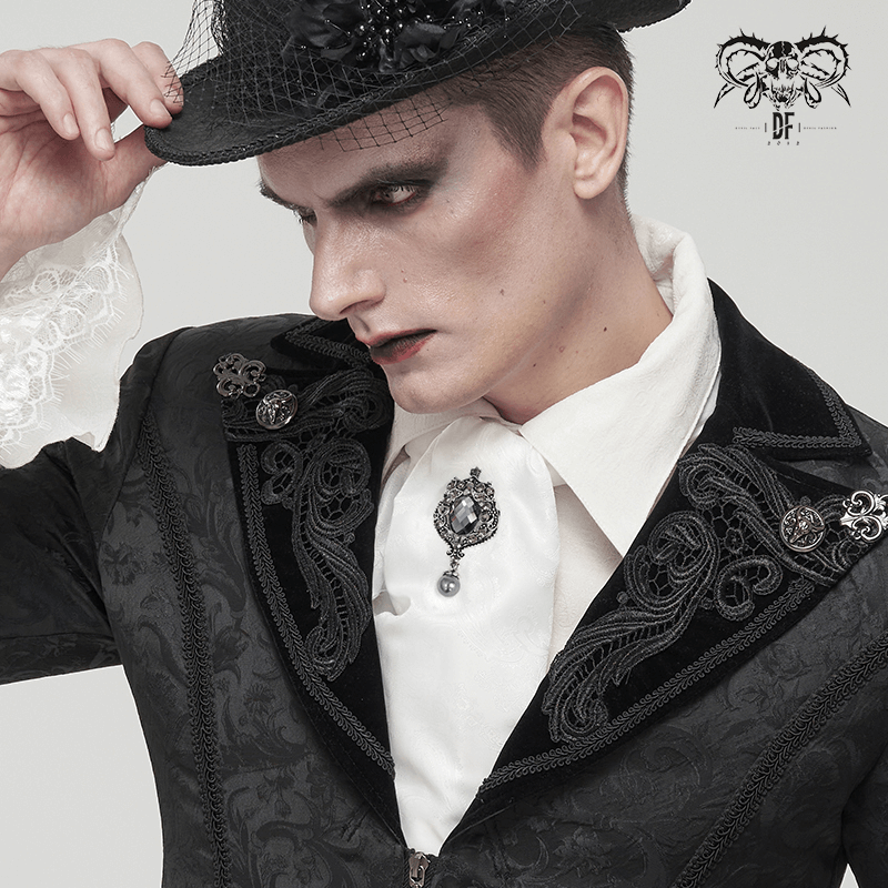 Gothic vintage male model showcasing a stylish black suit and white tie with crystal brooch for a unique fashion statement.