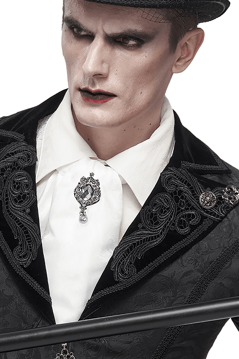 Gothic vintage male model wearing a white floral printed tie with a crystal brooch and ornate black attire.