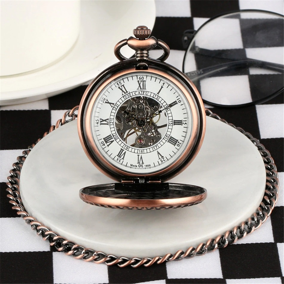 Vintage mechanical pocket watch with train design, bronze finish on a marble plate, surrounded by stylish decor.