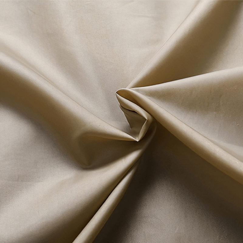 Close-up of smooth beige PU leather fabric, showcasing its soft texture and luxurious sheen for stylish jackets.