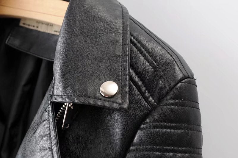 Close-up of vintage faux leather motorcycle jacket collar with stylish zippers and rivets, perfect for women's rock fashion.