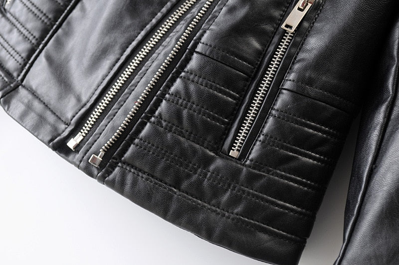 Close-up of a vintage black faux leather motorcycle jacket showcasing stylish zippers and quilted detailing.